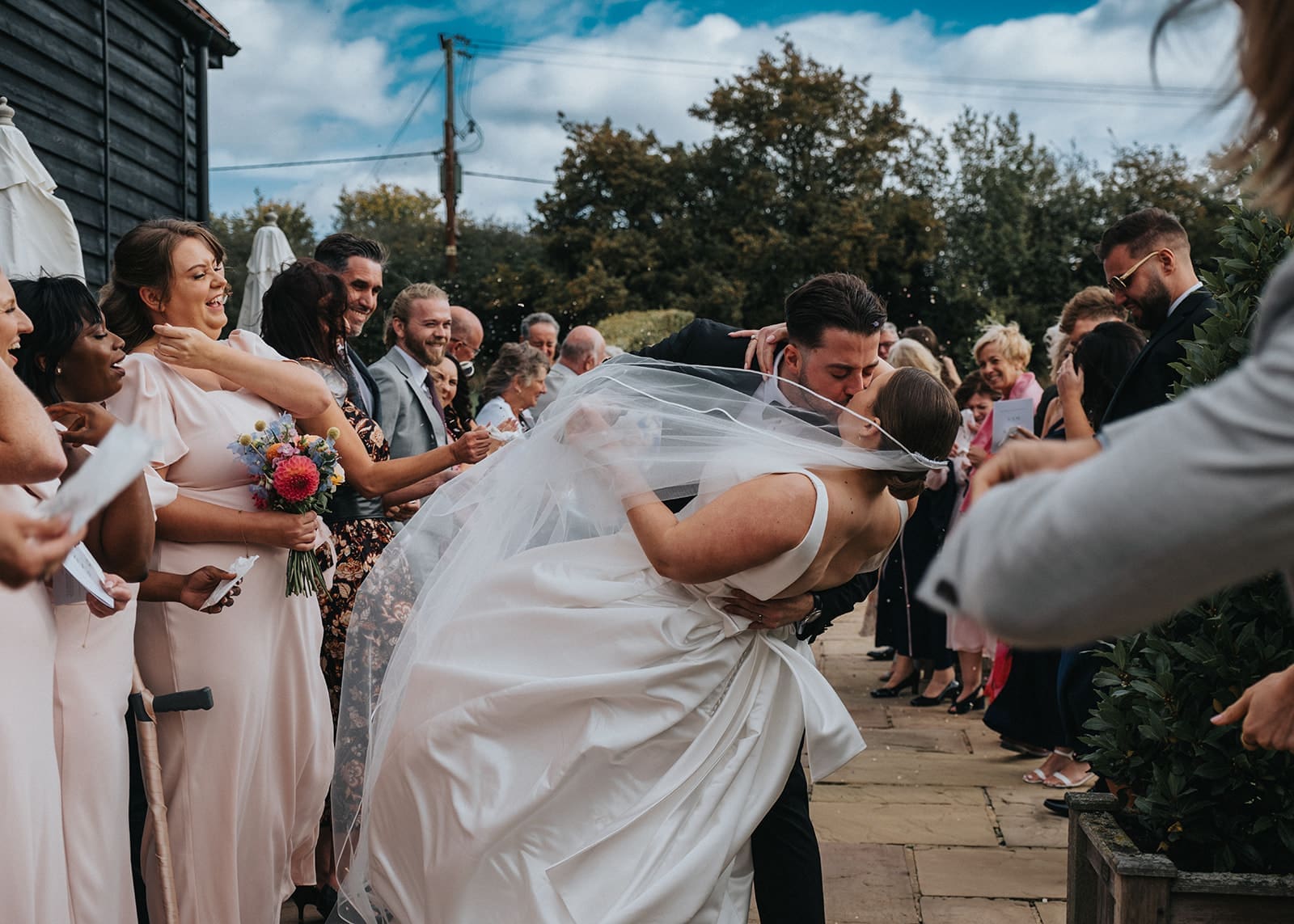Bride and groom kissing during a confetti moment at their Essex wedding, hosted by Liam Ball, wedding host in Essex.